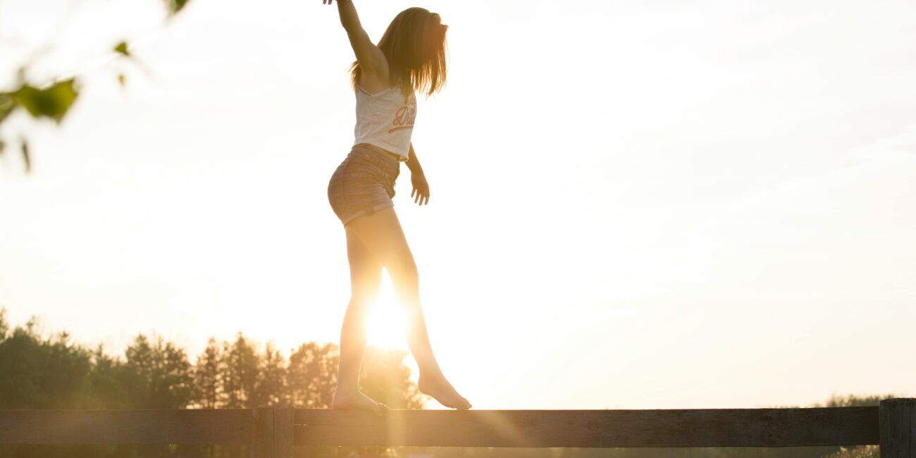 A girl walking across a beam and keeping her balance