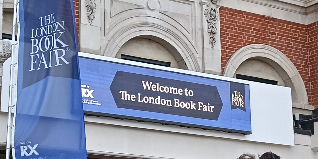 A blue sign on a building that reads 'Welcome to The London Book Fair'
